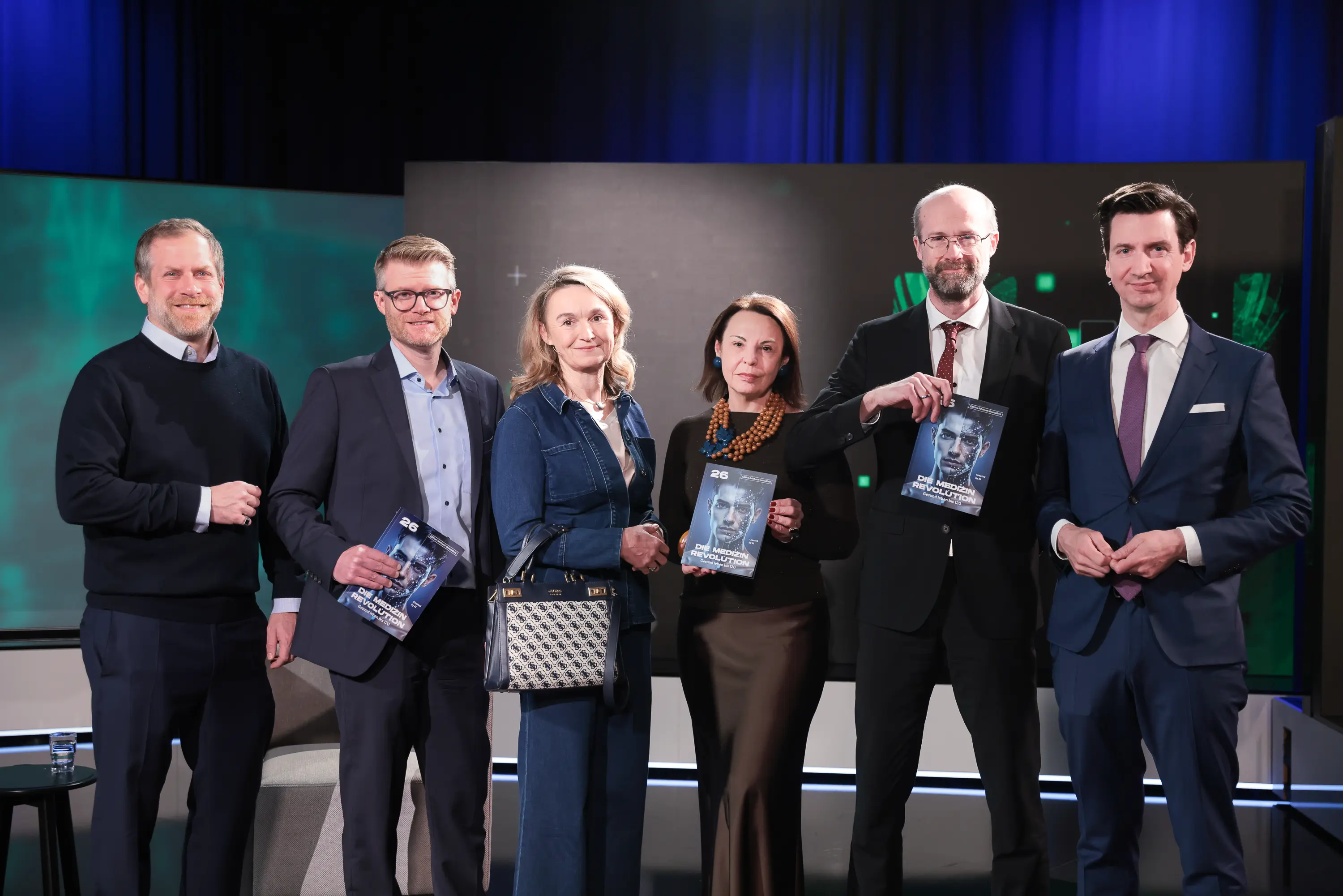 Impressionen von der Jahrbuch-Präsentation im PULS 24 Studio am 13. Jänner 2026. Die Bildergalerie zeigt verschiedene Momente der Veranstaltung mit Redner:innen am Podium, Gästen im Publikum und Teilnehmer:innen im Gespräch.